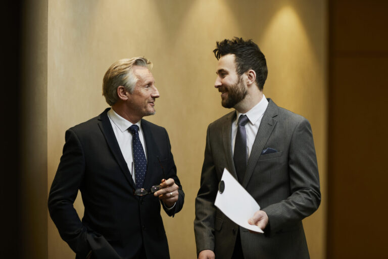 Two business professionals discussing documents, representing landlord record keeping, compliance and property management organisation
