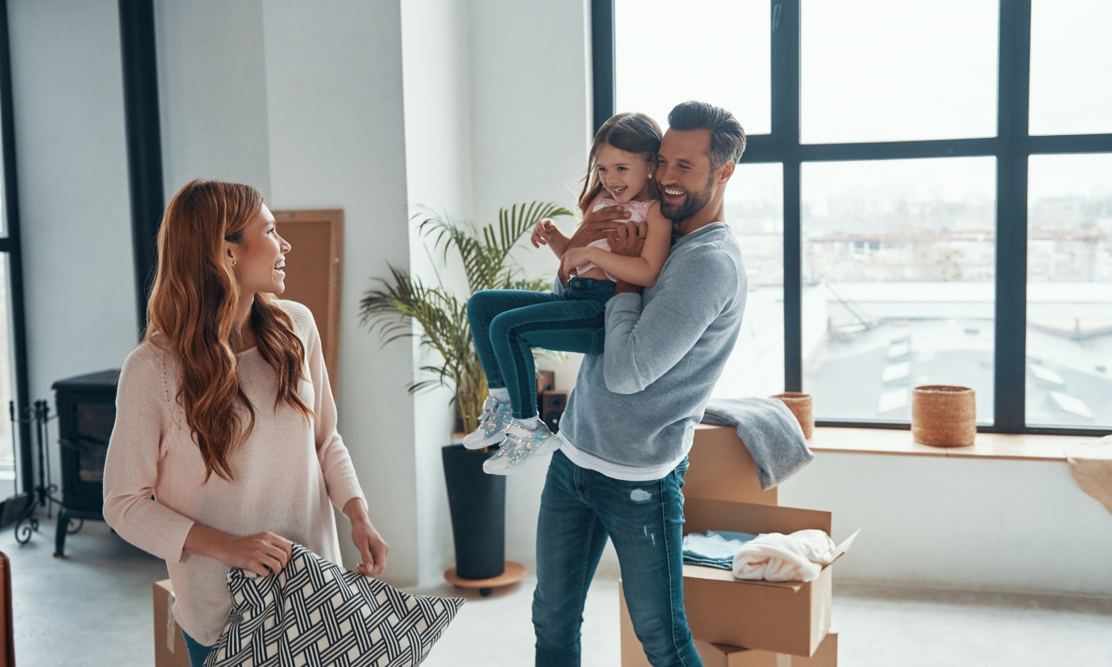 Young family settling into a modern rental property in Norfolk with moving boxes and bright living space