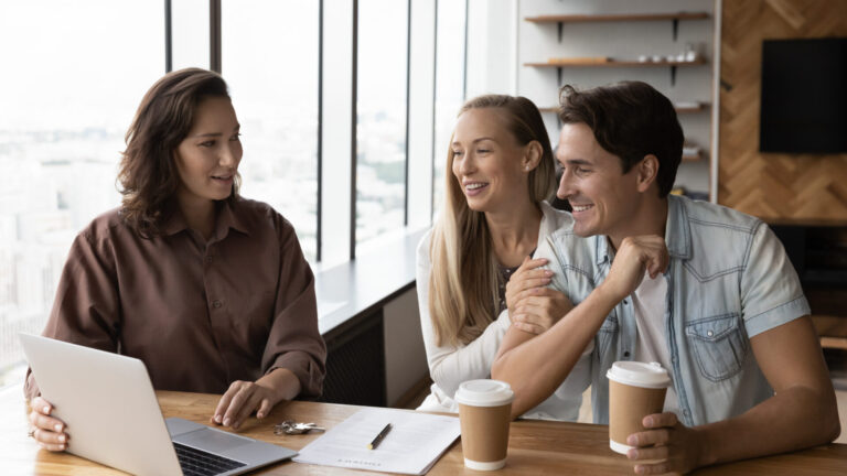 Property adviser speaking with a couple at a desk, representing Northwich buy-to-let advice and rental yield opportunities.