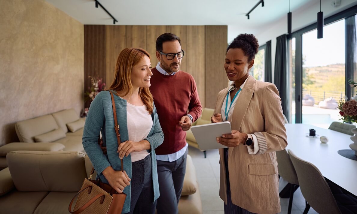 Letting agent showing a couple around a modern home, representing Christchurch rental areas for NHS staff and healthcare workers.
