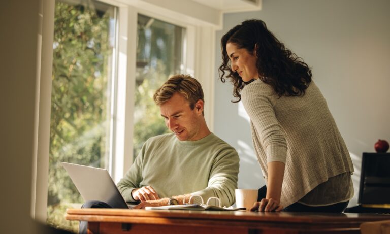 Couple reviewing property and rental investment information on a laptop at home, representing landlord decision-making in Stafford's rental market