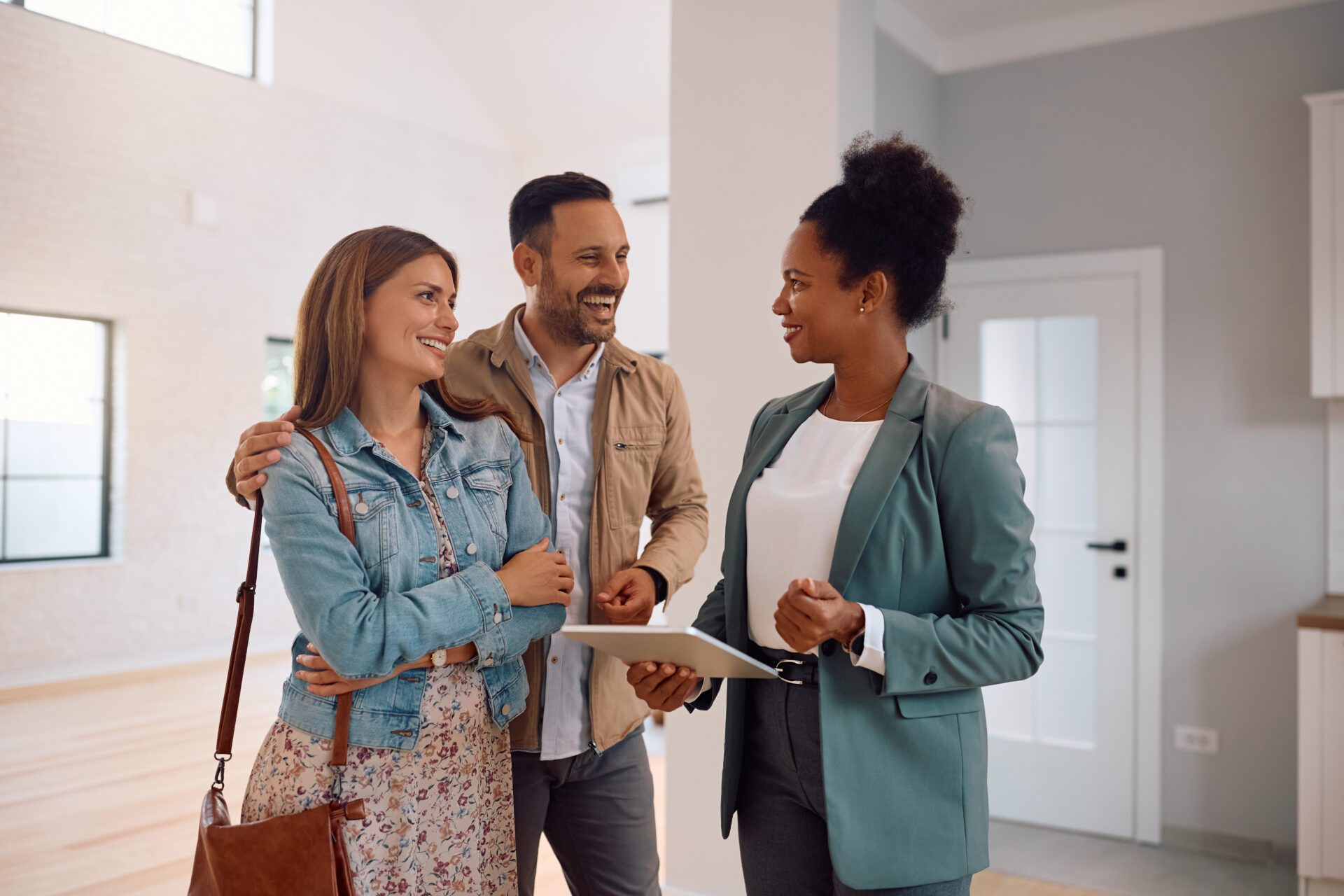 Letting agent speaking with a couple inside a property, representing professional advice for landlords renting out homes in Morley.