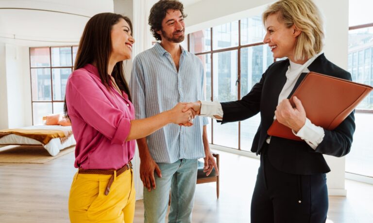 Letting agent shaking hands with prospective tenants during a property viewing in a modern rental home, illustrating the Northwich rental market and the relationship between landlords, tenants, and letting professionals in 2026.