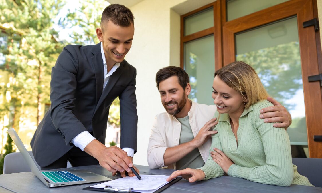 An estate agent reviewing property documents with a couple during a home-buying consultation, illustrating the process of purchasing a house in Stone, Staffordshire, and receiving expert local property advice.