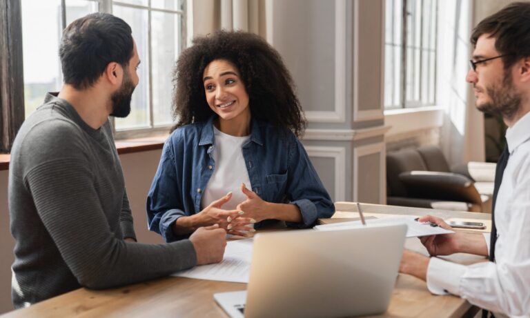 Letting agent discussing rental documents with landlords, representing professional advice on occupation contracts and landlord compliance in Swansea.