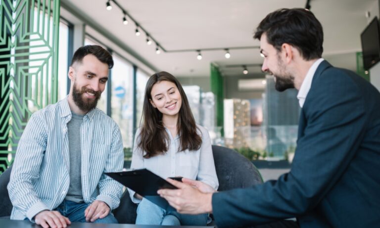 A letting agent discusses property details with a couple during a home viewing, illustrating first-time buyers exploring new housing opportunities in Tadley following the Skates Lane development in RG26.