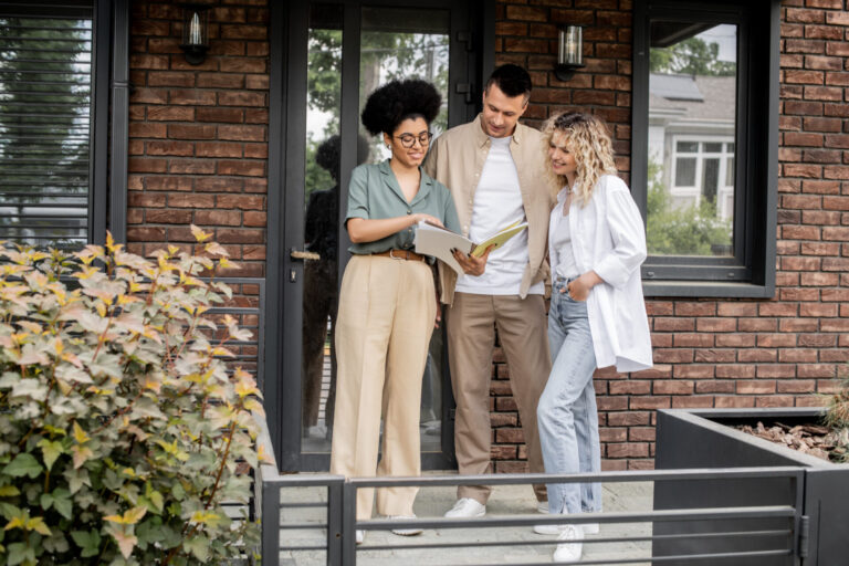 Letting agent reviewing property details with a couple outside a home, representing tenant demand and rental opportunities in Tilehurst.