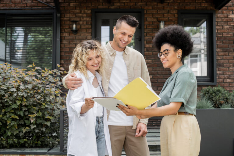 Letting agent discussing property documents with landlords outside a home, representing rental advice and landlord responsibilities in Guiseley.