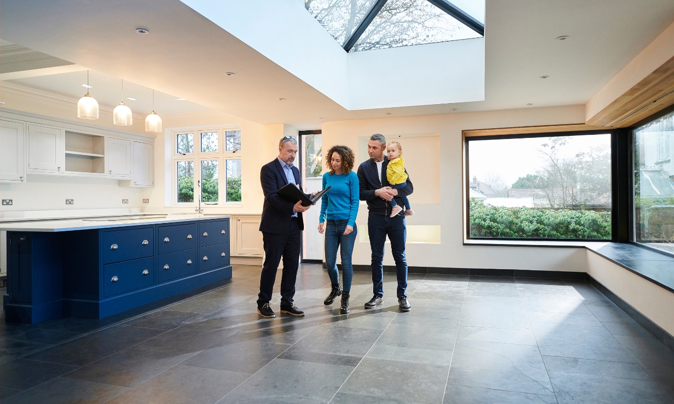 Estate agent showing a modern, energy-efficient home to prospective landlords or buyers during a property viewing, illustrating the type of well-insulated home discussed in the article about EPC upgrades for Christchurch rental properties.